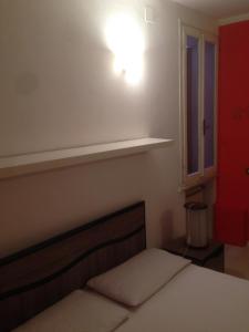 雷焦艾米利亞的住宿－punto G，一间卧室设有一张床、一个架子和一个窗户