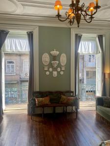 a living room with a couch and two windows at Sto António Vintage Studio in Porto