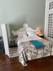 ein Schlafzimmer mit einem weißen Bett und einer grünen Bettdecke in der Unterkunft Sto António Vintage Studio in Porto