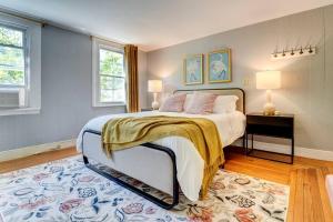 紐哈芬的住宿－New Haven Heaven - Foosball - Near Yale，一间卧室设有一张大床和两个窗户。