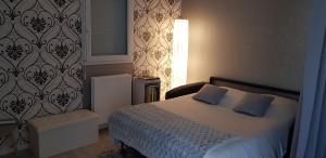 - une chambre avec un lit doté d'oreillers bleus et d'une lampe dans l'établissement Au jardin de la seiche, à Noyal-Châtillon-sur-Seich