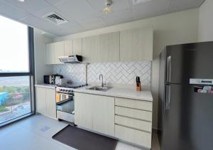 a kitchen with a refrigerator and a sink at Letstay - Misty Rosa 1BR Apartment in Dania 3 With Balcony in Dubai
