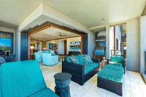ein Wohnzimmer mit blauen Möbeln und einem Balkon in der Unterkunft Wailea Beach Villas M312 condo in Wailea
