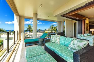 een woonkamer met een bank en een balkon met uitzicht op de oceaan bij Wailea Beach Villas M312 condo in Wailea