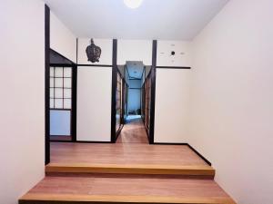 um corredor de uma casa com paredes brancas e pisos de madeira em Jun Resort em Chiba