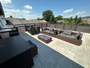 a patio with couches and a table on a roof at M&M Apartments in Augustdorf