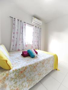 馬拉戈日的住宿－Apartamento 1 à 200m da praia de Maragogi，一间卧室配有带色彩缤纷枕头的床。