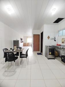 馬拉戈日的住宿－Apartamento 1 à 200m da praia de Maragogi，厨房配有桌椅和炉灶。
