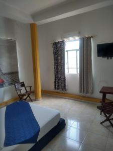 a bedroom with a bed and a television and a window at Hotel Central Park in El Espinal