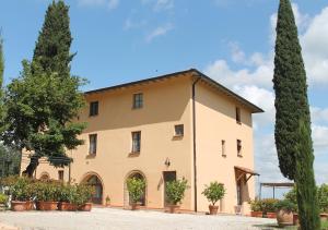 un grand bâtiment avec des arbres devant lui dans l'établissement Villa Le Ripe, à Gambassi Terme