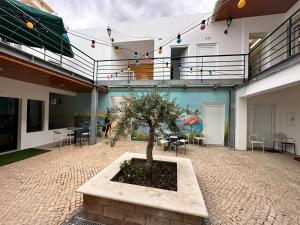 a courtyard with a tree in a planter in front of a building at Albergaria Formosa in Faro