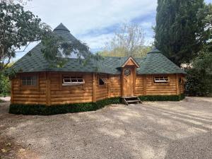 a large wooden cabin with a gambrel roof at La Vallée De Taradeau in Taradeau