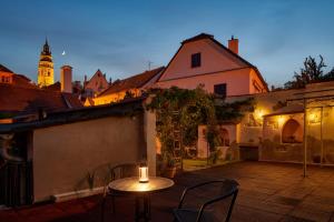 um pátio com uma mesa e cadeiras à noite em Orangerie em Cesky Krumlov