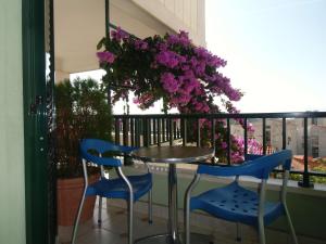 una mesa y sillas en un balcón con flores púrpuras en Apartments Mustapic, en Makarska