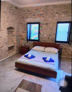 a bedroom with a bed with blue napkins on it at Stone tower east mani 4 in Agriliá