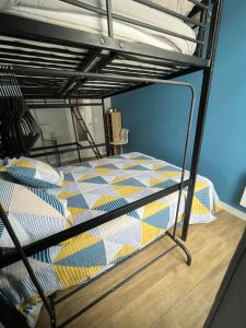 - un lit superposé avec une couette colorée dans l'établissement Appartement Chaleureux 2 pièces, à Sète