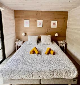 una camera da letto con un grande letto con due cuscini gialli di GITE AR MILIN a Cordemais