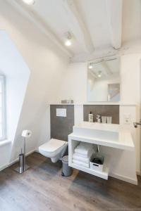La salle de bains blanche est pourvue de toilettes et d'un lavabo. dans l'établissement Stadthaus Monschau Garden&Green (8 Gäste), à Monschau