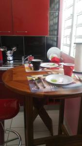 Una mesa de madera en una cocina con platos y utensilios. en ptit coin hibiscus en Pointe-Noire