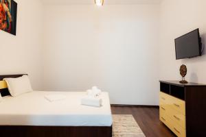 Schlafzimmer mit einem Bett und einem TV in der Unterkunft Old City in Bukarest