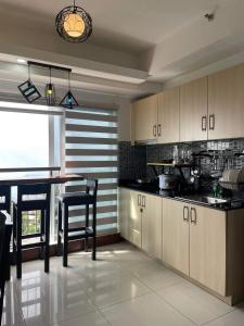a kitchen with a counter and a table and chairs at WIND RESIDENCES SMDC TOWER 2 in Tagaytay