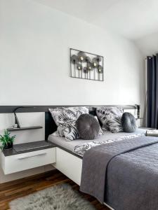 ein Schlafzimmer mit einem Bett mit Kissen darauf in der Unterkunft Ebony & Ivory Ferienwohnung in Steinhude