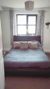 a bedroom with a bed with pillows and a window at Cosy flat close to city centre. in Nether Edge