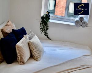 a bed with pillows on it with a window at Quirky Modern Two Bedroom Apartment By Sahara Suites Short Lets & Serviced Accommodation Newcastle in Newcastle upon Tyne