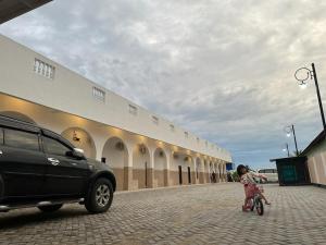 GRAND PANDAN HOTEL في Halangan: فتاة صغيرة تركب دراجة أمام المبنى