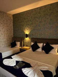 GÜNEŞLİ AİRPORT SUİTE HOTEL في إسطنبول: غرفه فندقيه سريرين في غرفه