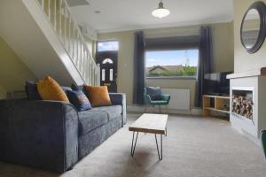 a living room with a blue couch and a table at Lovely 2-Bedroom Home in Langley Park, Sleeps 4 in Durham