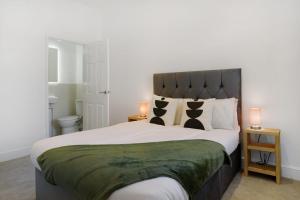 1 dormitorio con 1 cama grande y 2 lámparas en Lovely 2-Bedroom Home in Langley Park, Sleeps 4, en Durham