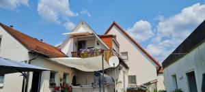 una casa con un ombrello appeso a un balcone di Ferienwohnung, Urlaub im Frankenwald a Konradsreuth
