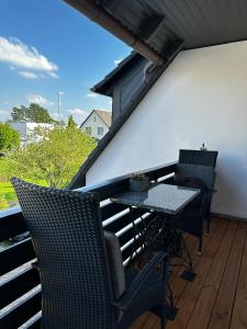 ein Balkon mit Tisch und Stühlen auf einer Veranda in der Unterkunft Ebony & Ivory Ferienwohnung in Steinhude