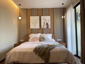 Stay.vie Hotel في سورابايا: غرفة نوم بسرير مع صورتين على الحائط