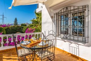 a table on the balcony of a house at Casa Los Olivos in Nerja