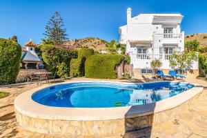 a swimming pool in front of a house at Casa Los Olivos in Nerja