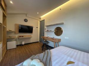 Habitación con cama, escritorio y TV. en Stay.vie Hotel, en Surabaya