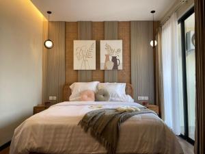 a bedroom with a bed with three pictures on the wall at Stay.vie Hotel in Surabaya