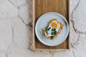 a plate of food with an egg on a wooden tray at Alma Maya Resort in Puerto Morelos