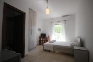 a bedroom with a bed and a window at Mato Rooms in Himare