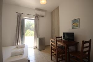 a room with a bed and a table and a television at Mato Rooms in Himare