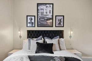 a bedroom with a large bed with four pictures on the wall at Exquisite Georgian Apartment with Reserved Parking in Wakefield