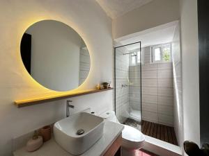 y baño con lavabo blanco y espejo. en Outstanding House in San Benito!, en San Salvador