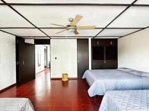 1 dormitorio con 2 camas y ventilador de techo en Outstanding House in San Benito! en San Salvador