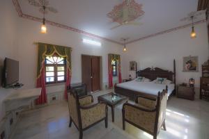 a bedroom with a bed and a table and chairs at Ranakpur Safari Resort in Sādri