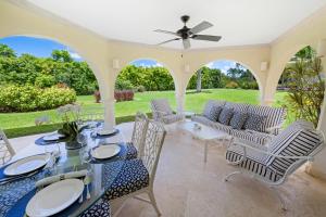 a patio with a table and chairs and a garden at Royal Westmoreland - Royal Apartment 214 by Island Villas in Saint James