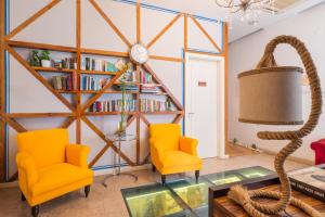 uma sala de estar com duas cadeiras e uma estante de livros em Lisboa Prata Boutique Hotel em Lisboa