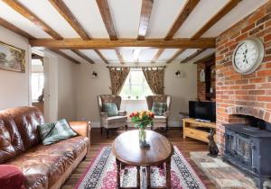 a living room with a couch and a fireplace at Locks Lane Cottage in Geldeston