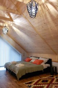 sypialnia z dużym łóżkiem w drewnianym suficie w obiekcie Harmonia Horyniec w mieście Horyniec